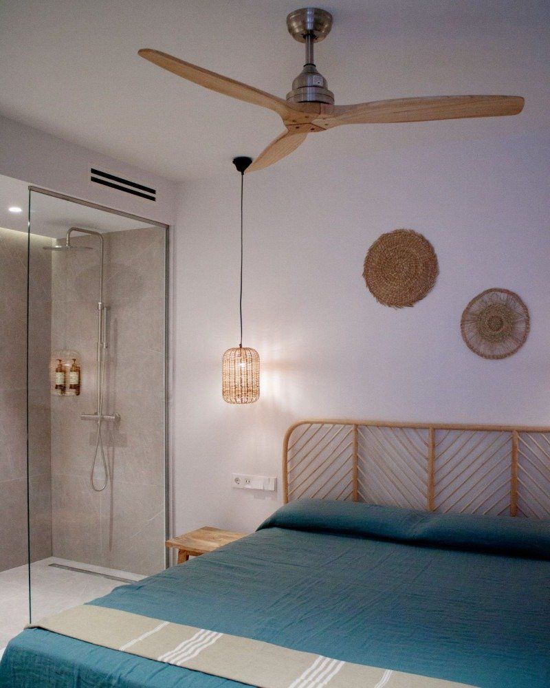 A bedroom with a bed and a ceiling fan