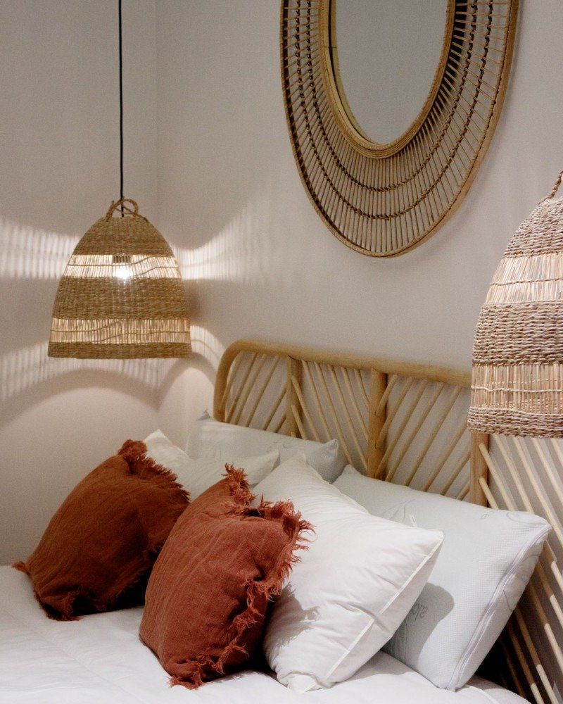 A bed with pillows and a mirror on the wall