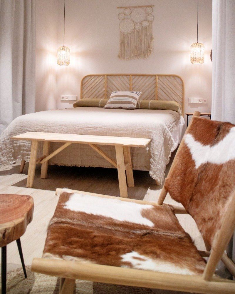 A bedroom with a bed , bench , chair and table