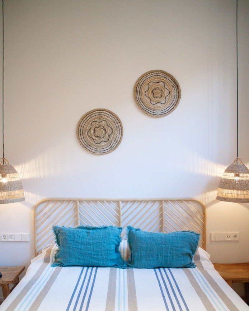 A bedroom with a bed and two baskets on the wall