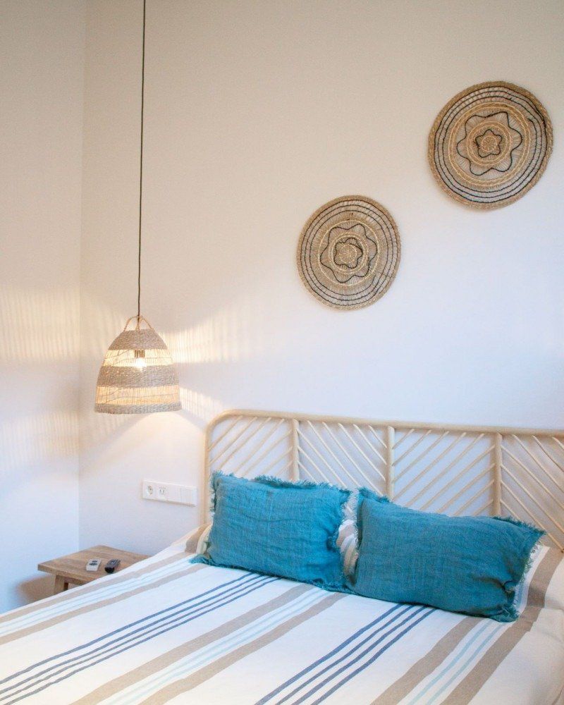 A bedroom with a bed and two baskets on the wall
