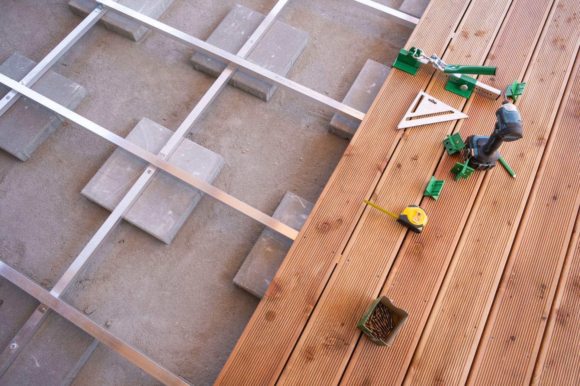 Workers installing insulation on a sloped roof with white framing on the left and orange panels on the right