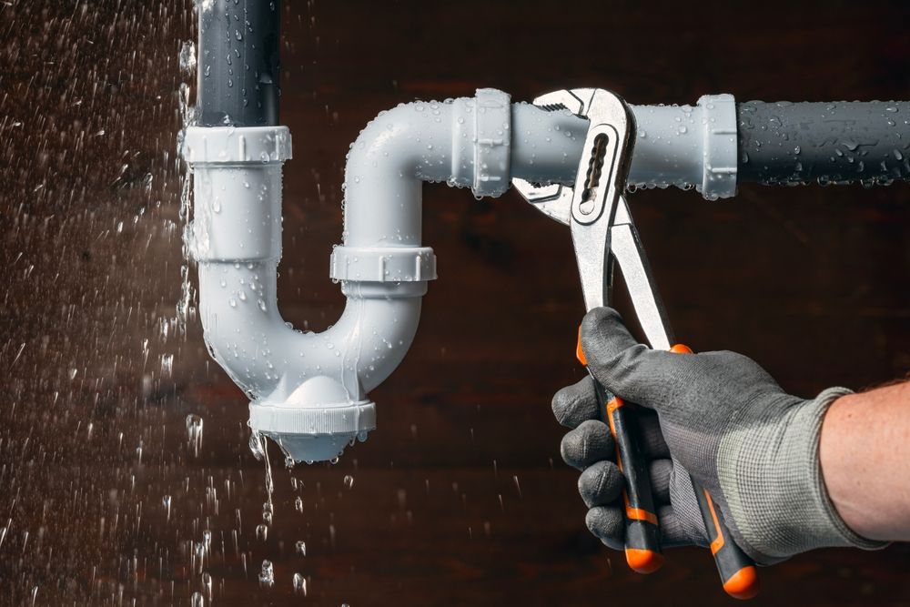 Hand holding wrench on pipe