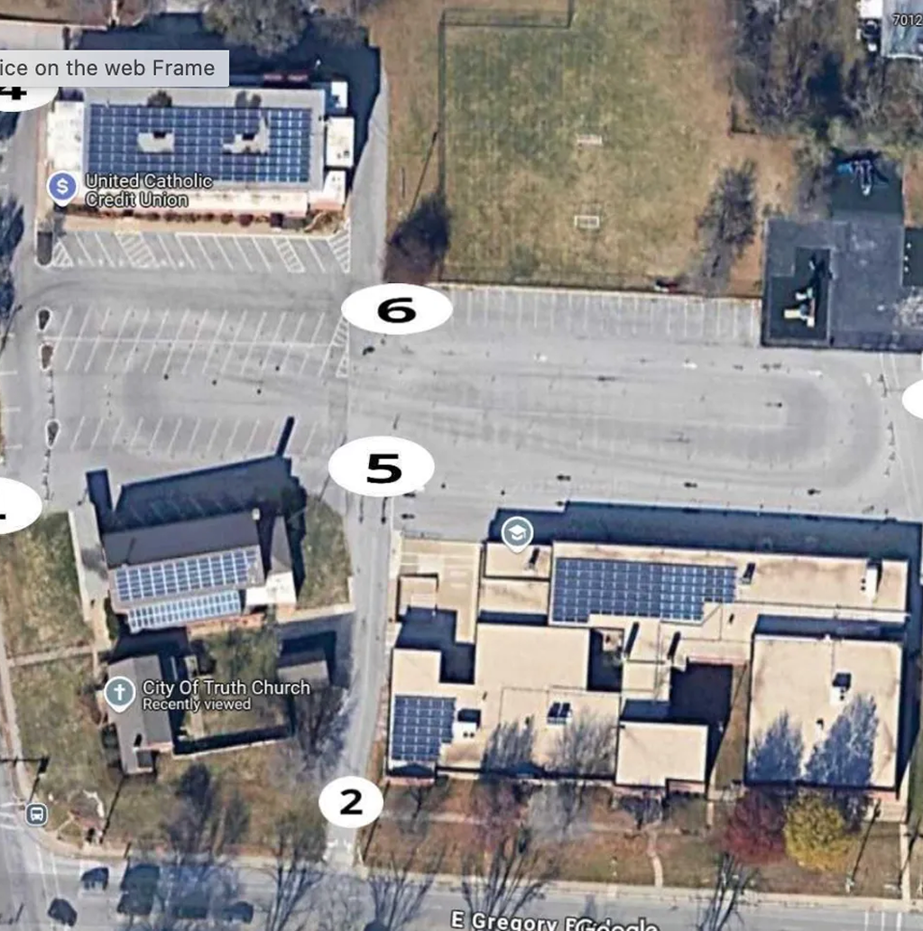 Aerial view of a parking lot and adjacent buildings with several numbered markers.
