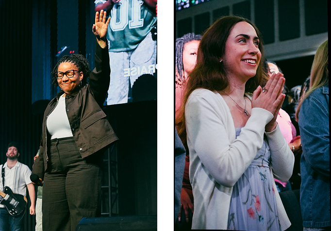 Two people on a stage, one waving and one smiling with hands clasped in front of a crowd.