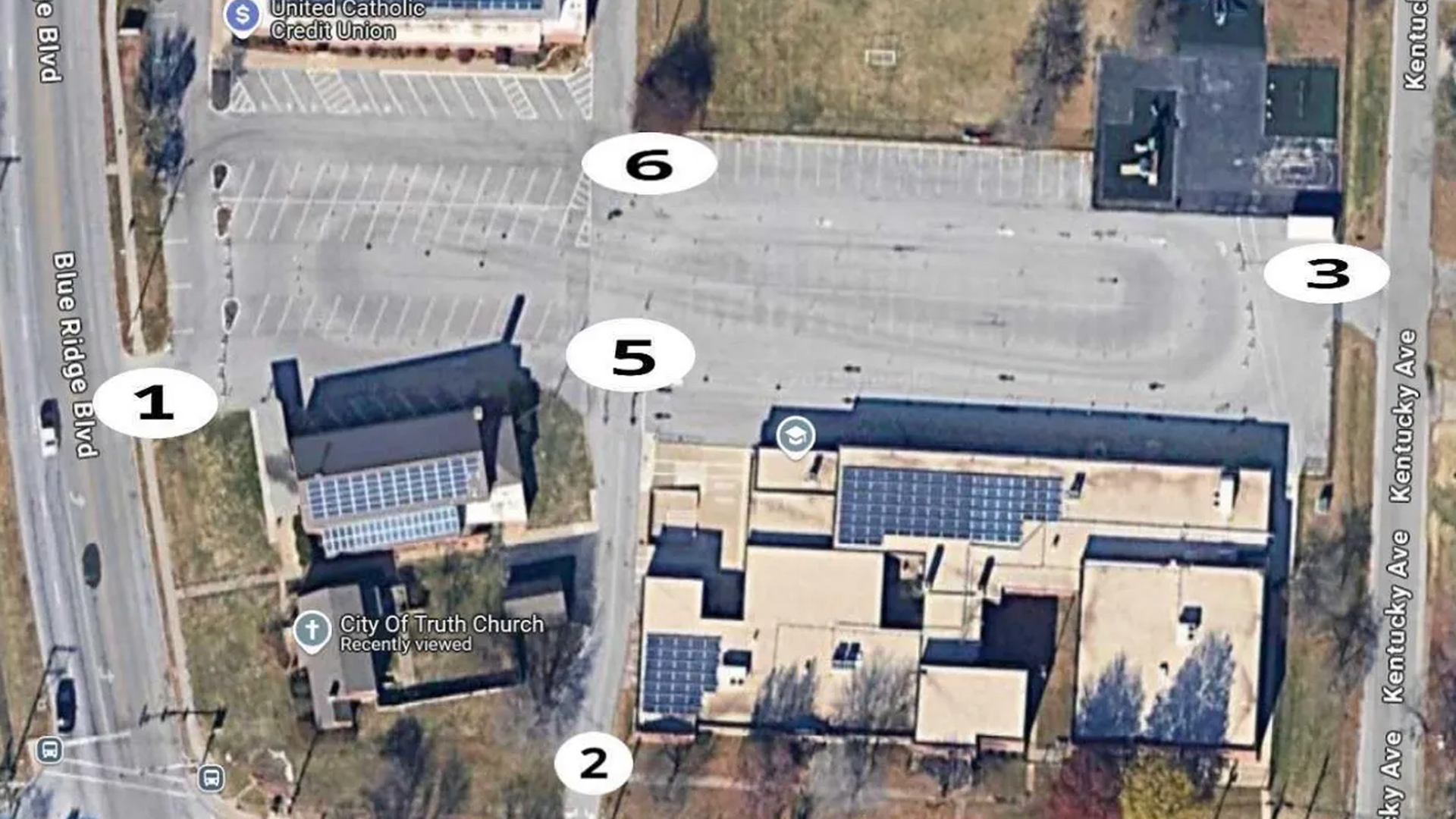 Aerial view of a parking lot and adjacent buildings with several numbered markers.