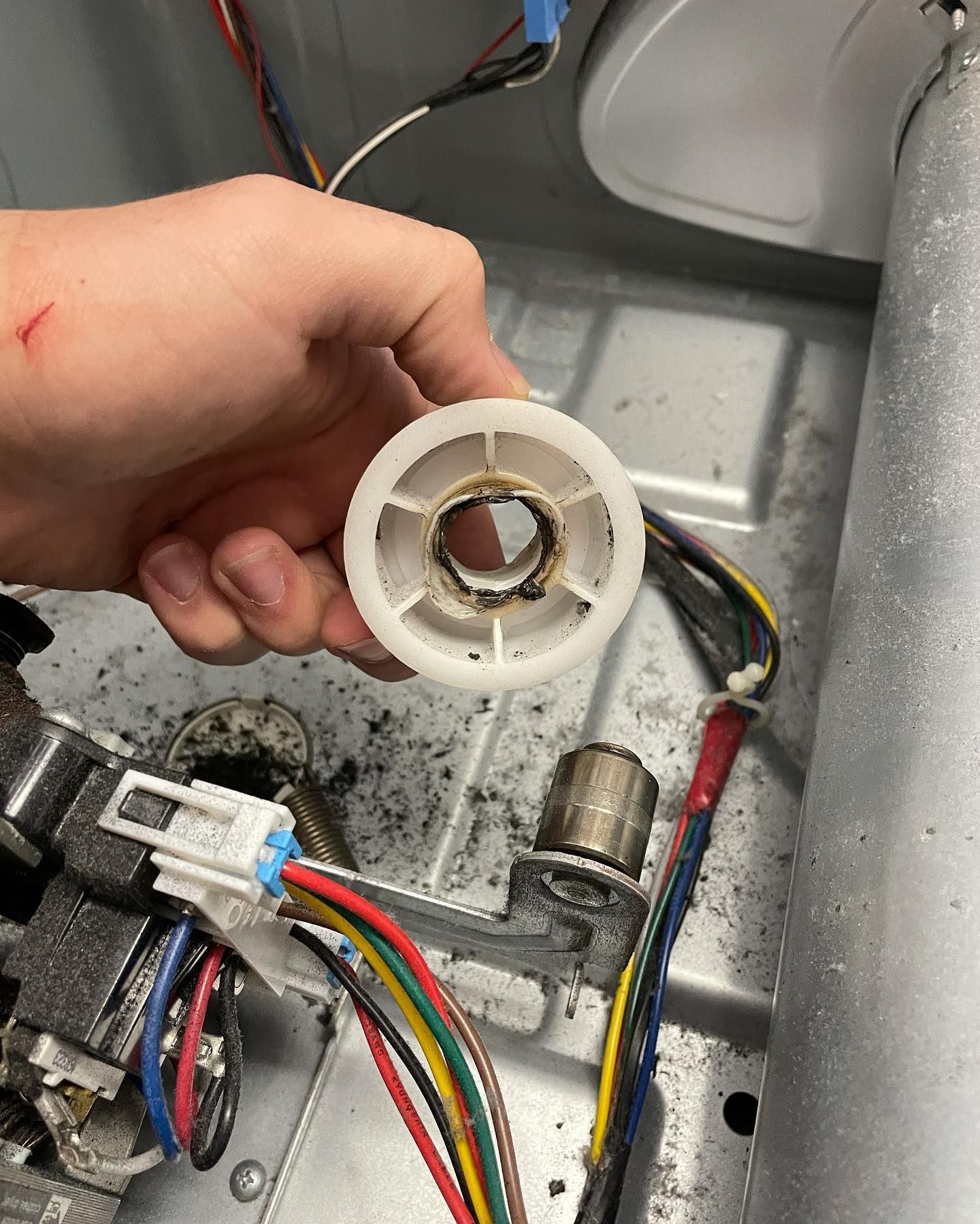 A person is holding a white wheel in their hand.