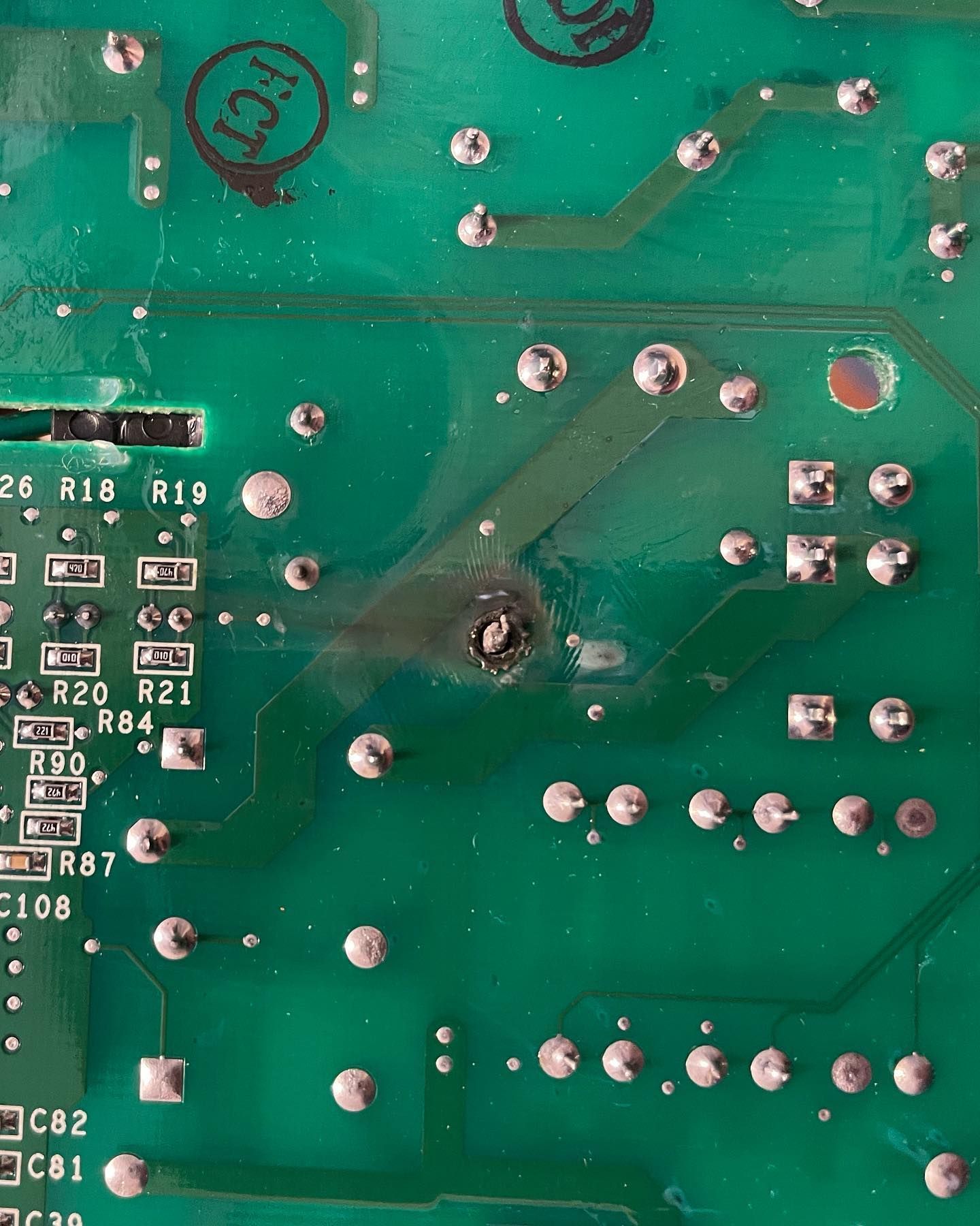 A close up of a green motherboard with a hole in it