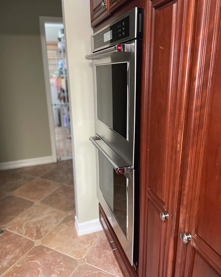A kitchen with wooden cabinets and a stainless steel oven.
