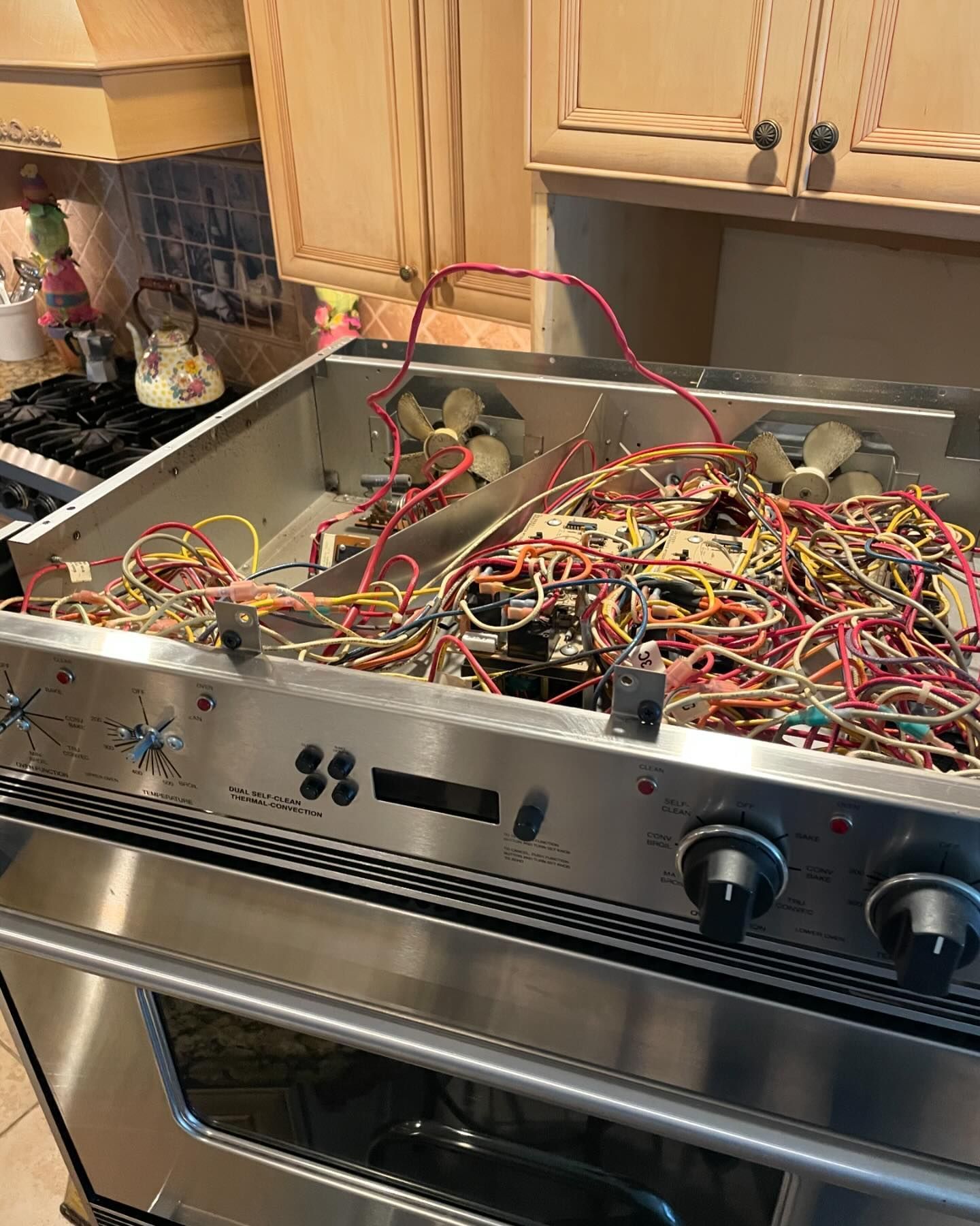 A stove top oven with a bunch of wires coming out of it.