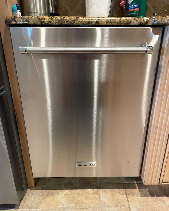 A stainless steel dishwasher is sitting under a counter in a kitchen.