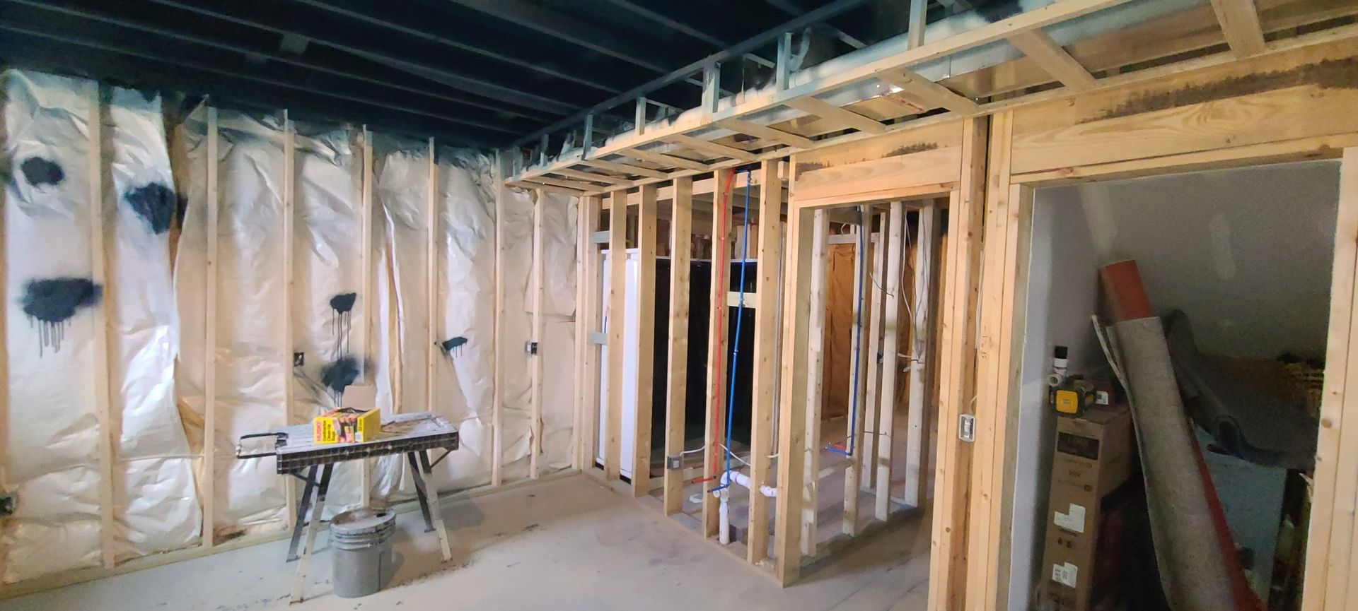 A room with a lot of wooden frames and a table saw in it.