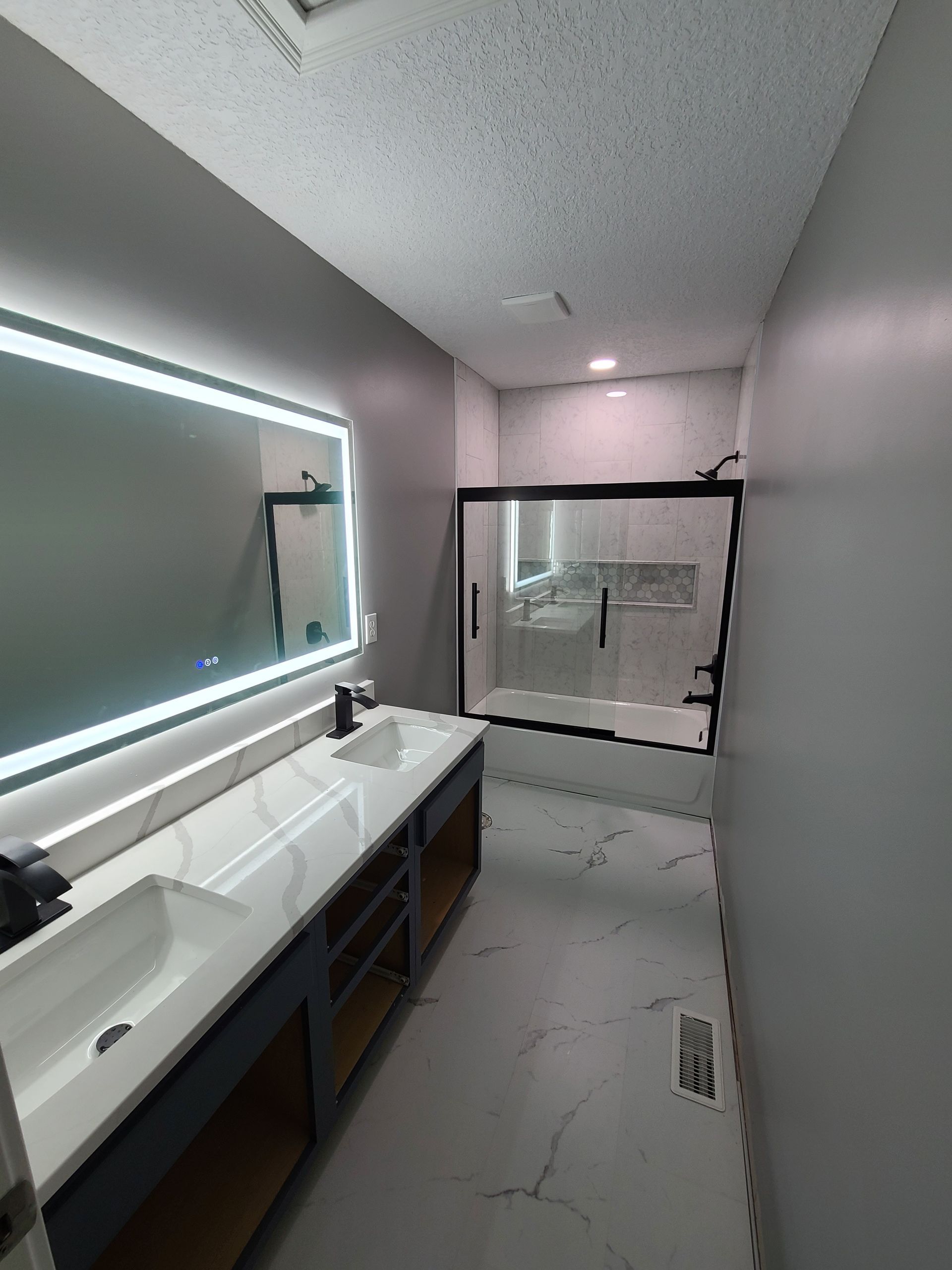 A bathroom with two sinks and a large mirror