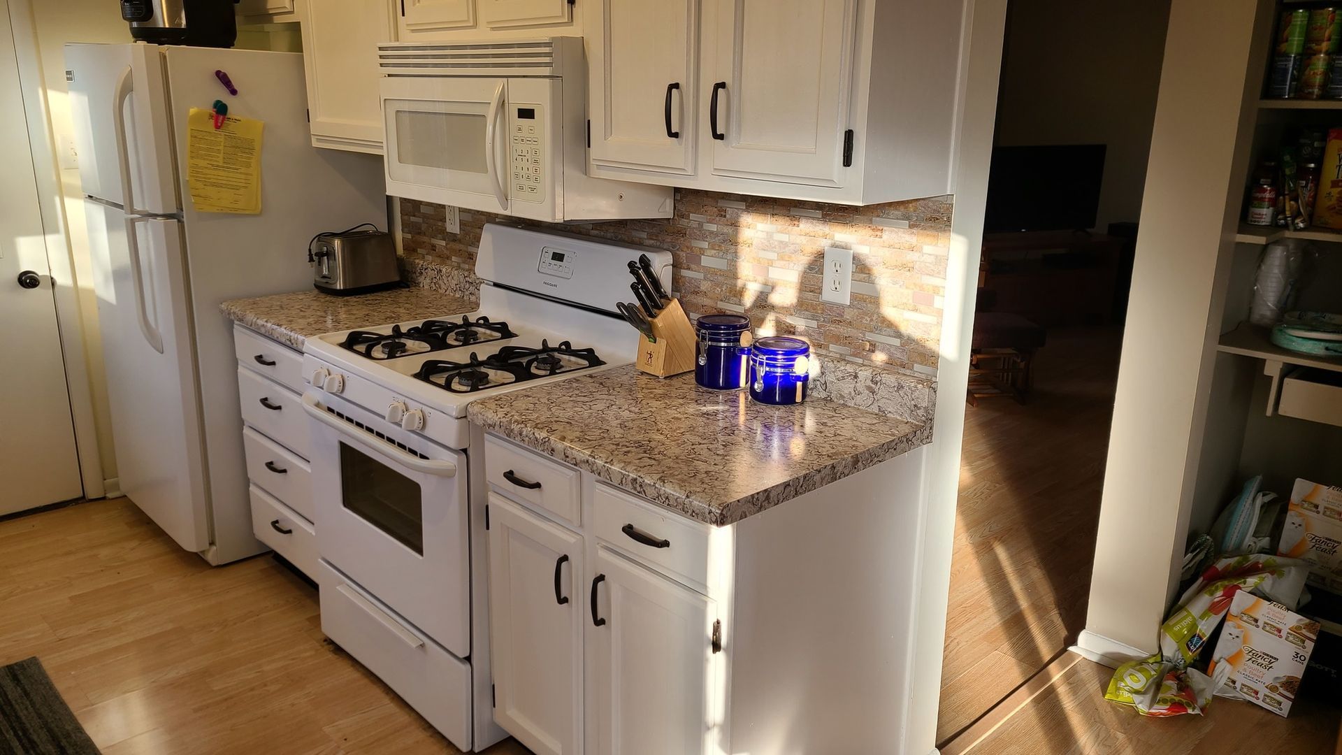 A kitchen with white cabinets and granite counter tops