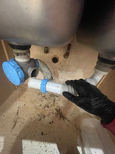 Equipo de destapaciones trabajando en un baño moderno con maquinaria profesional.