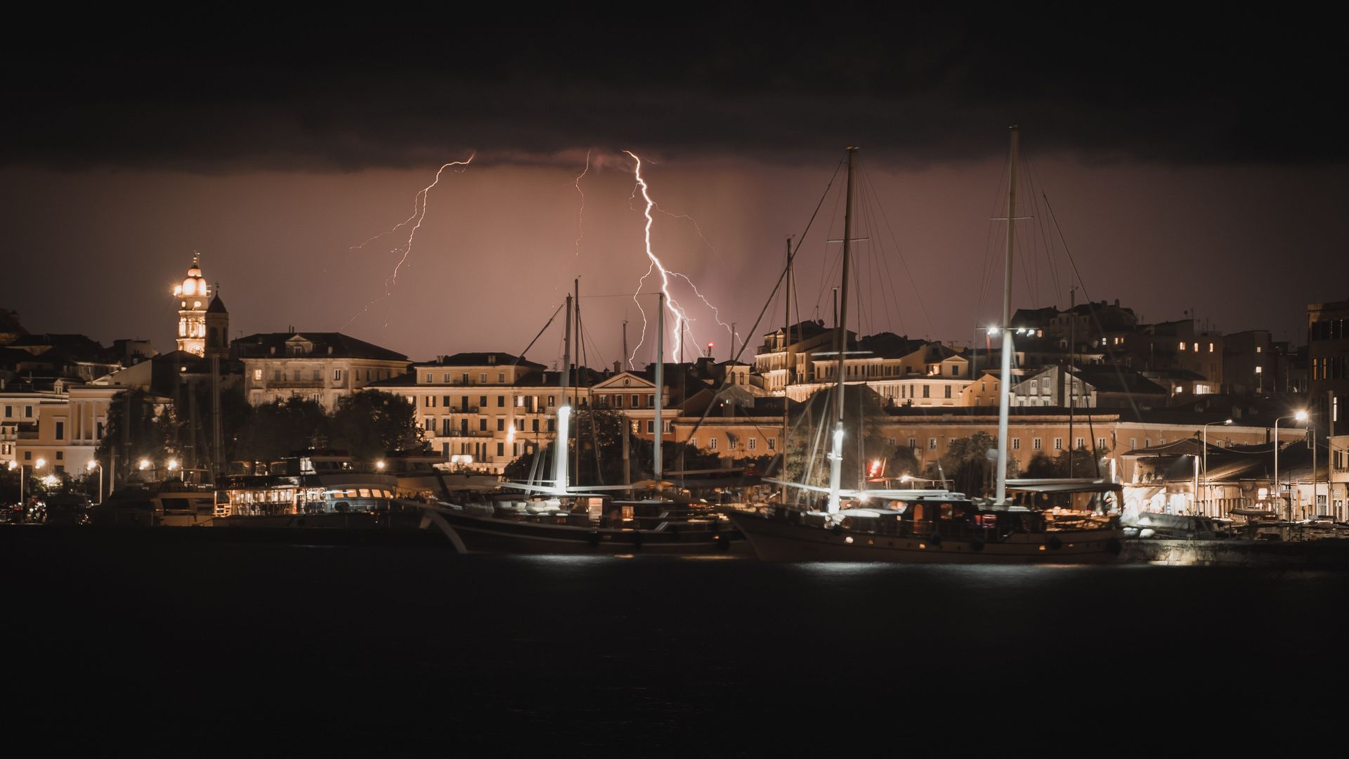 Lightning strike over a South Florida marina at dusk with boats docked along the pier