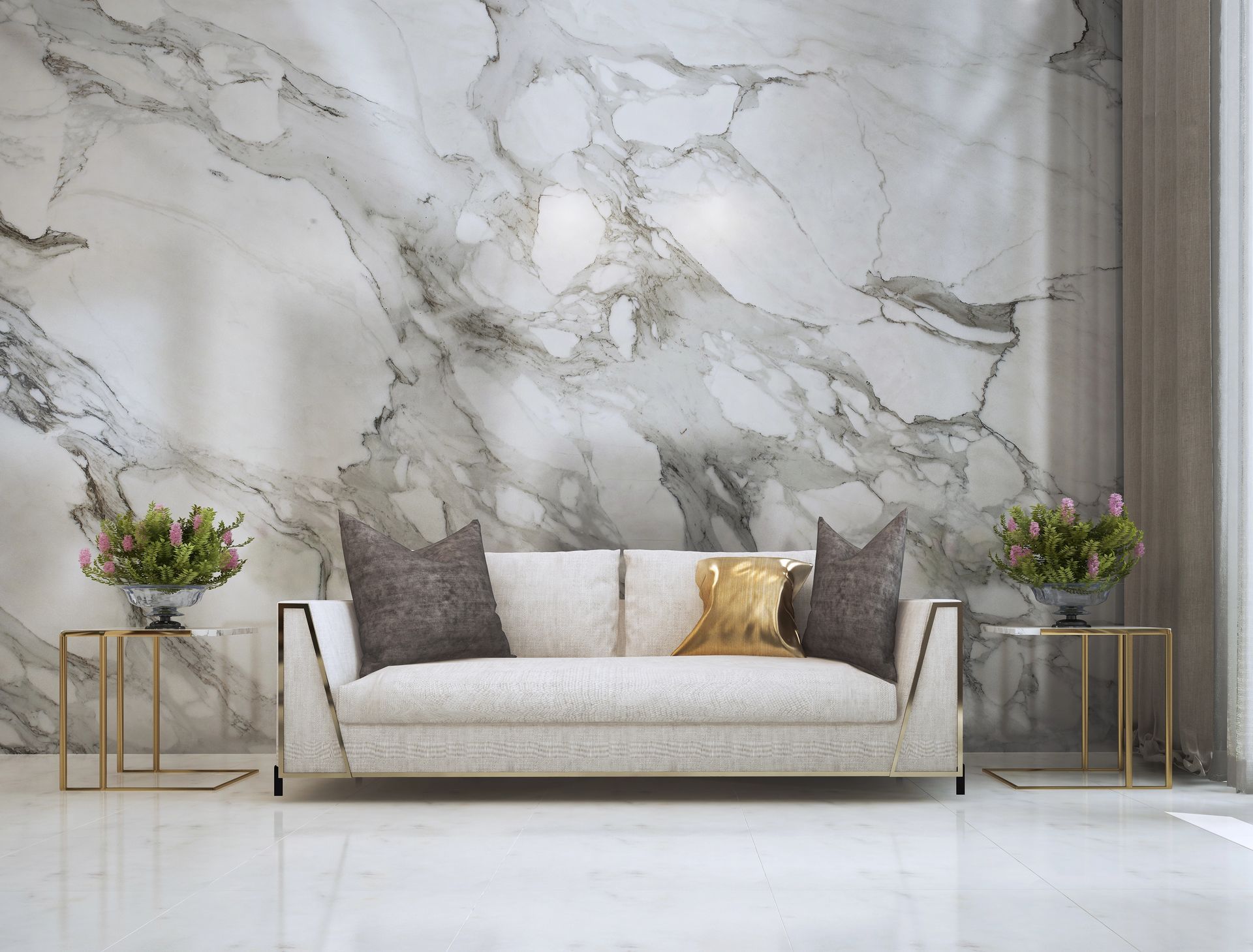 Soggiorno moderno con divano color crema, parete in marmo e tavolini laterali dorati con fiori.