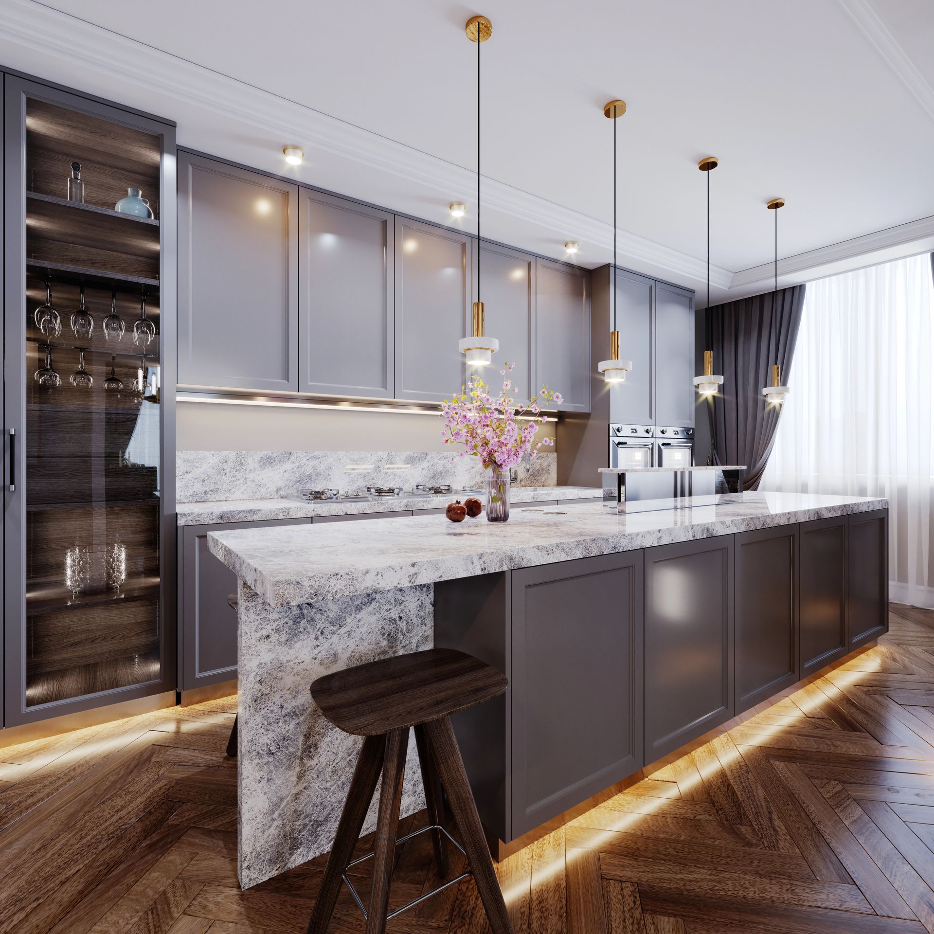 Cucina moderna con mobili grigi, isola in marmo, lampade a sospensione e illuminazione calda sotto i pensili.