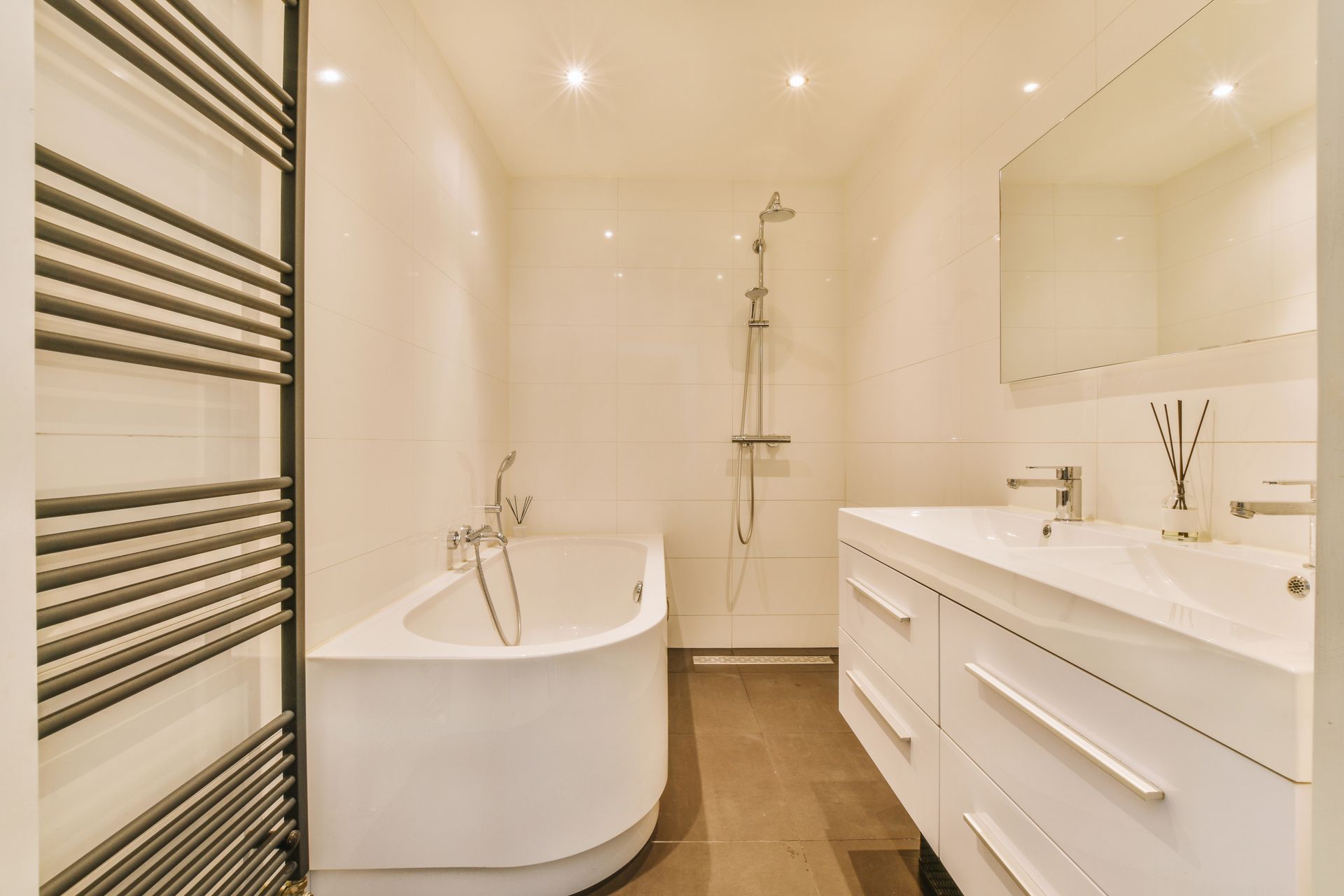 Luminoso bagno moderno con vasca freestanding, cabina doccia e doppio lavabo.