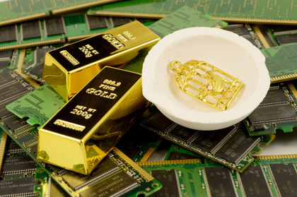 Gold bars and a gold chip on a pile of green circuit boards