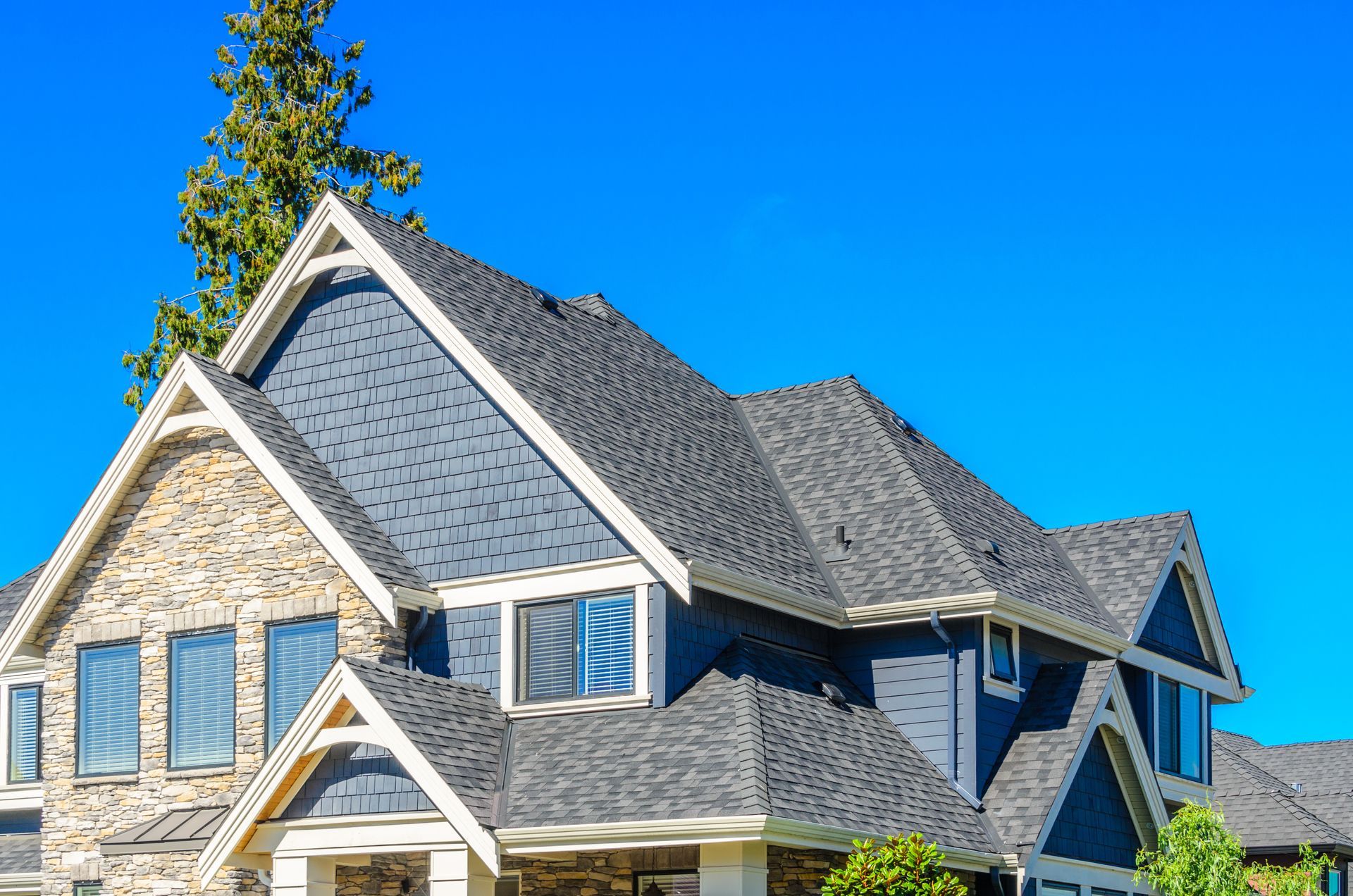 House with blue siding and gray roof against a clear blue sky. House with blue siding and gray roof against a clear blue sky.