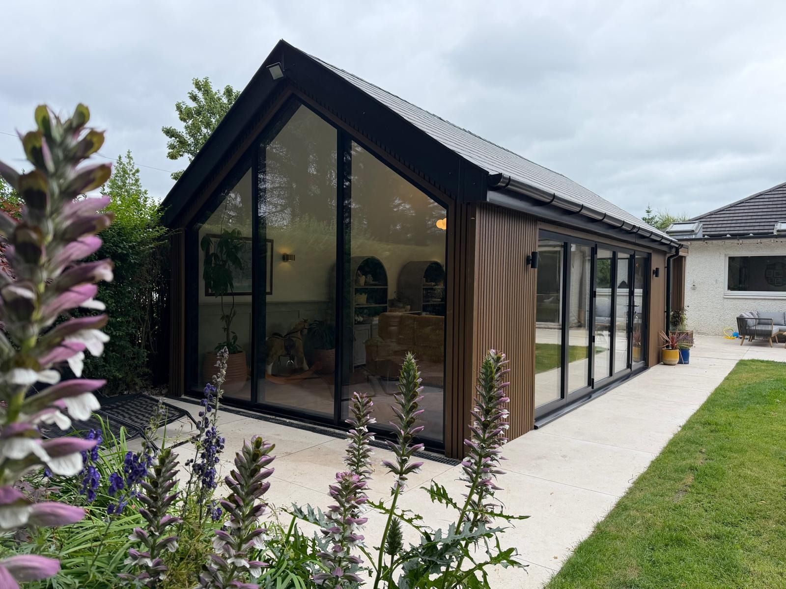 Completed Oakspan pitched roof garden room and landscaped terrace in Newton Mearns
