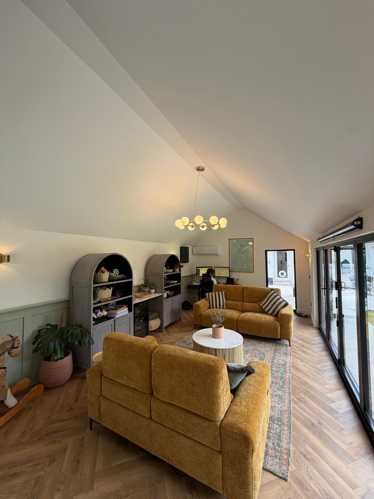 Oakspan garden room interior with full height glazed gable and herringbone flooring