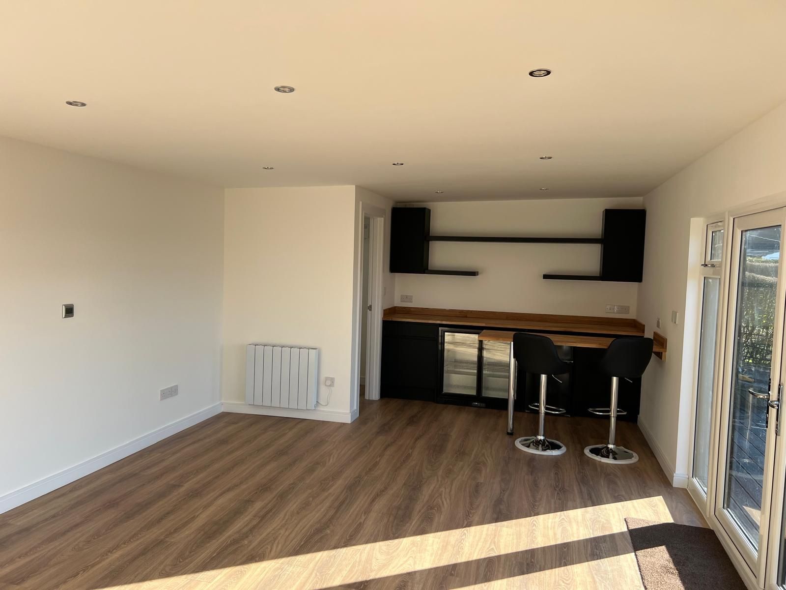 Bearsden family garden room interior with fitted bar, television and cinema space