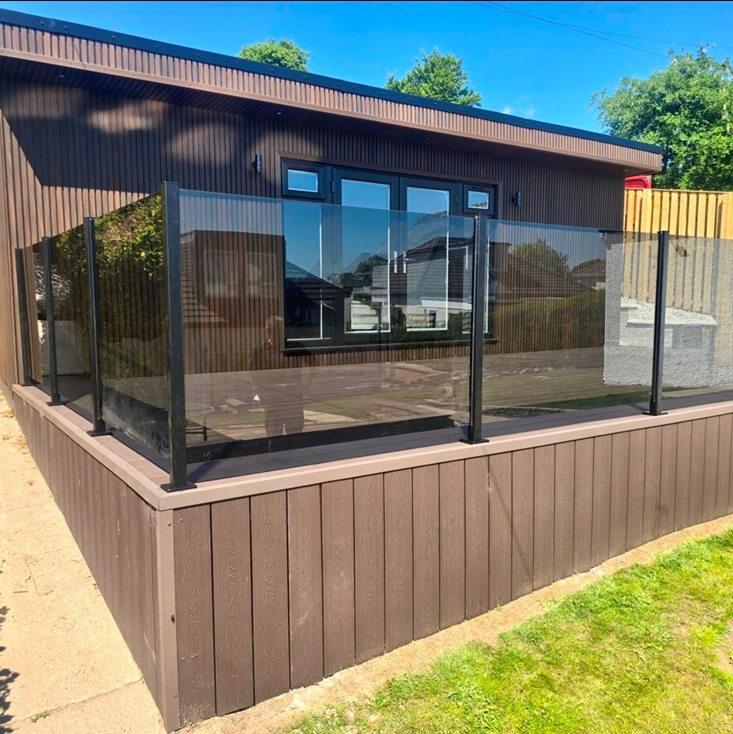 Large Oakspan family garden room with raised composite deck and glass balustrade in Bearsden