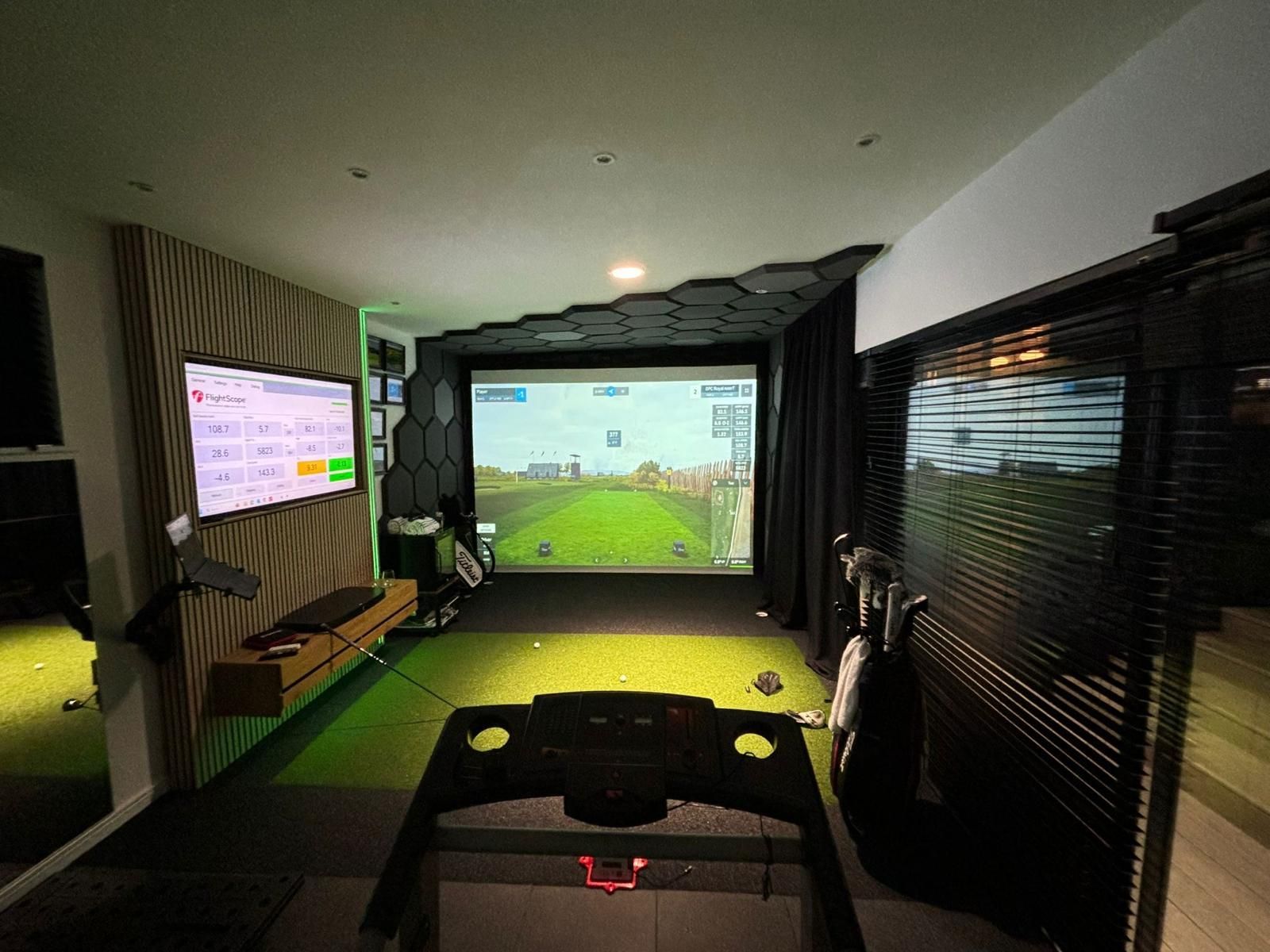 Spacious dual-purpose interior featuring a high-fidelity golf simulator, integrated gym area, and immersive home cinema setup, designed for both performance and relaxation