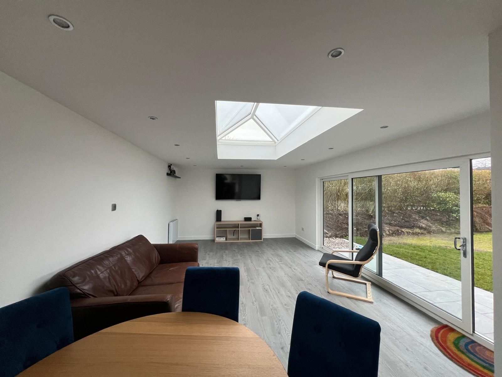 Modern interior of a garden games room with toilet, underfloor heating, and a 3m x 1.5m double-glazed roof lantern providing natural light throughout.