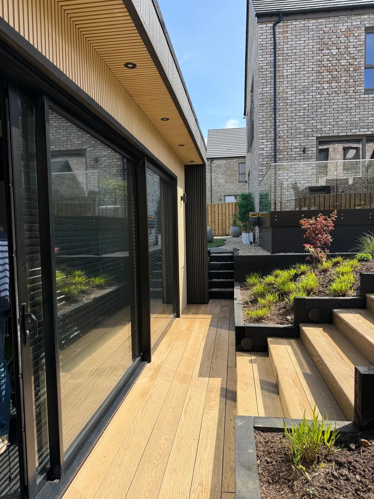 Light oak and midnight black composite cladding on an Oakspan garden room in Glasgow