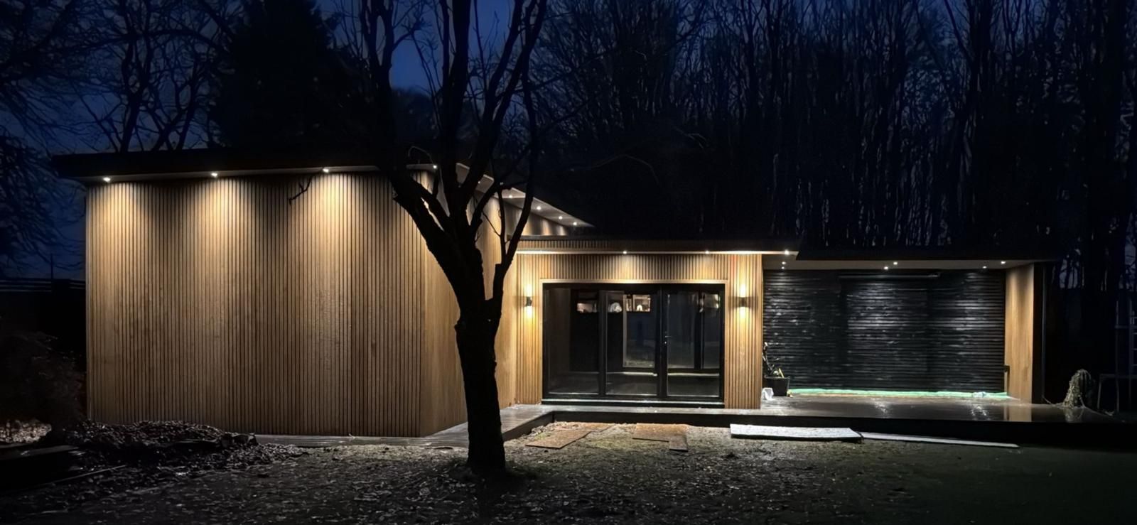 Kilmarnock Oakspan golf simulator, gym and cinema garden room illuminated at night