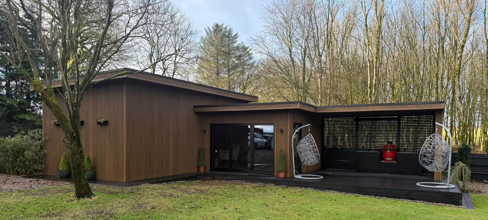Completed Oakspan golf simulator, gym and cinema garden room in Kilmarnock with covered outdoor kitchen and wraparound composite decking