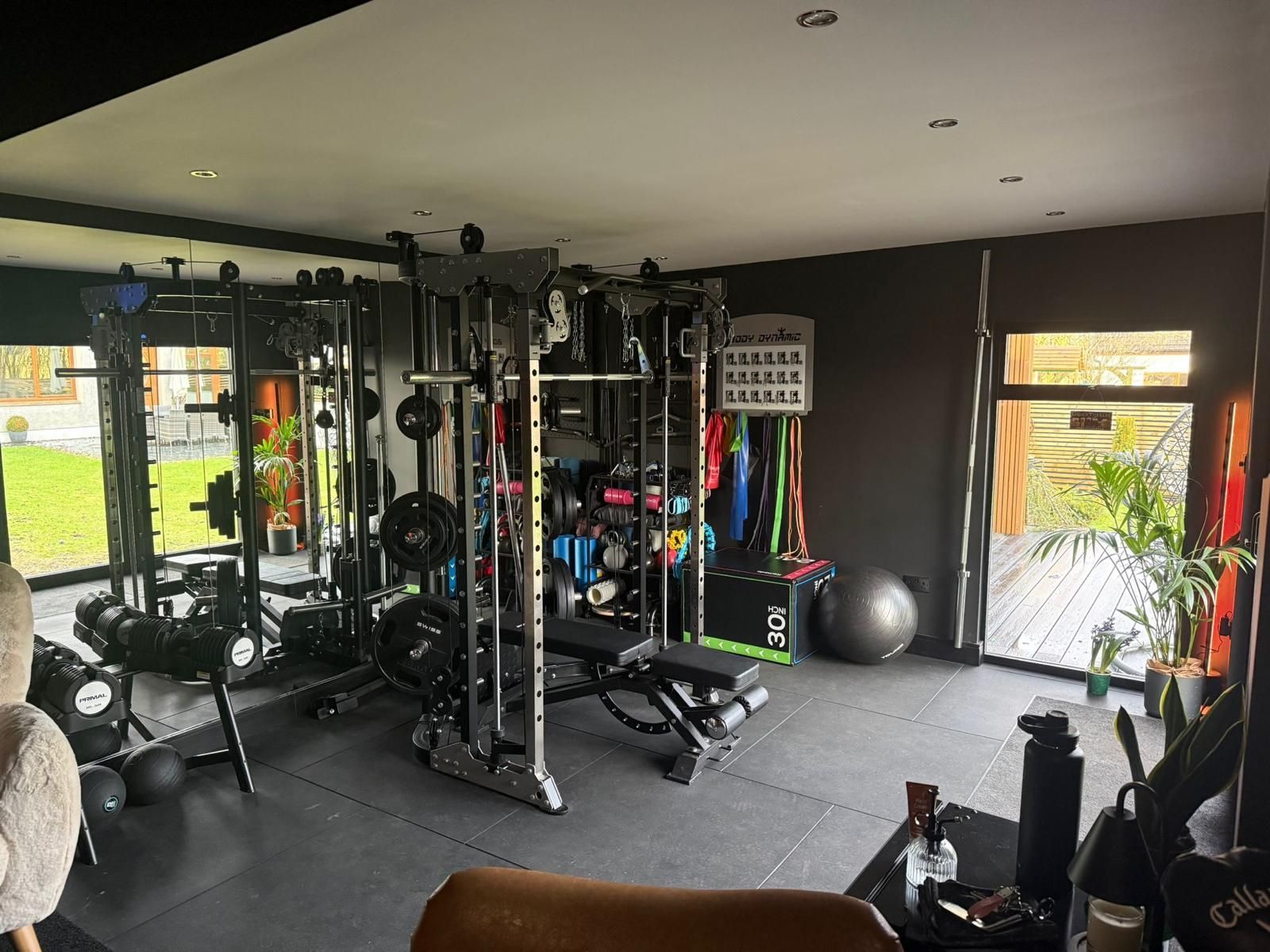 Interior view connecting the golf simulator and gym areas of the bespoke Oakspan garden room in Kilmarnock