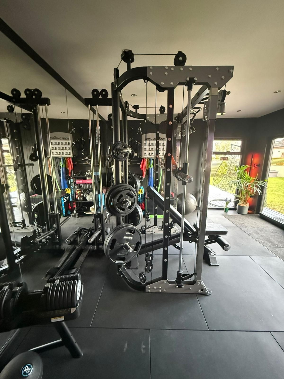 Open-plan home gym inside the Oakspan Kilmarnock garden room with rubber flooring and floor-to-ceiling mirror