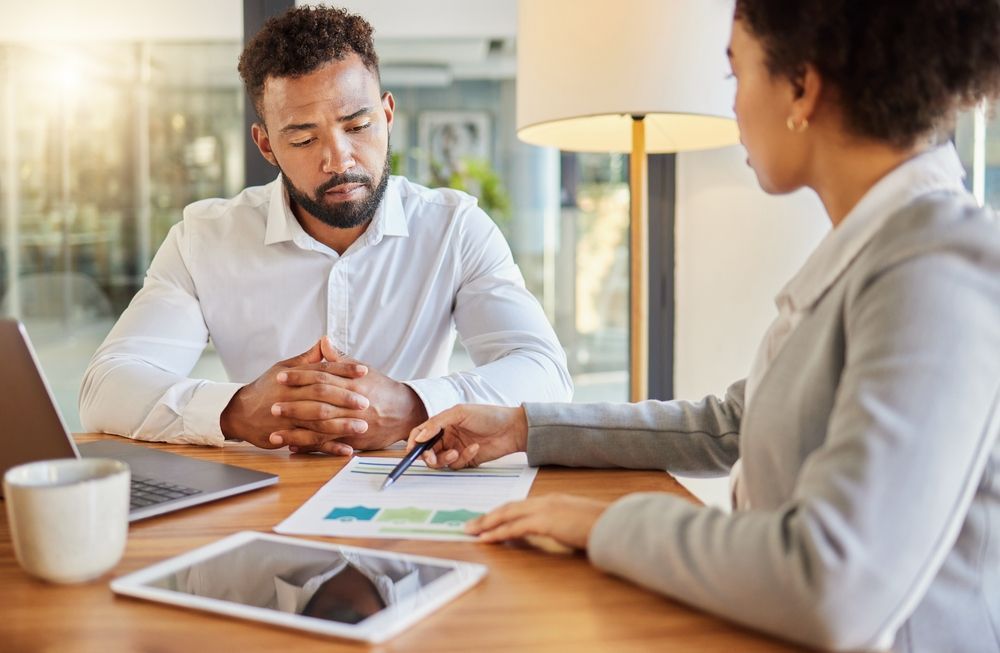 A fractional CFO and a business owner are reviewing financials, the business owner is experiencing the the benefits of a fractional CFO