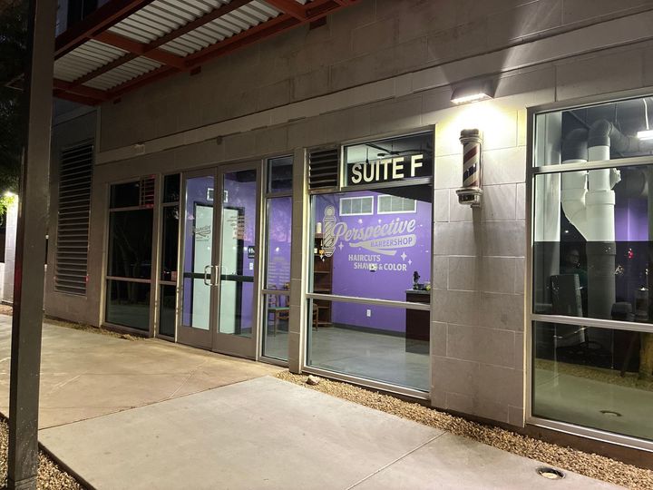 A storefront for a barber shop named “Perception” at Suite F, featuring purple walls, large glass windows, and a pole.