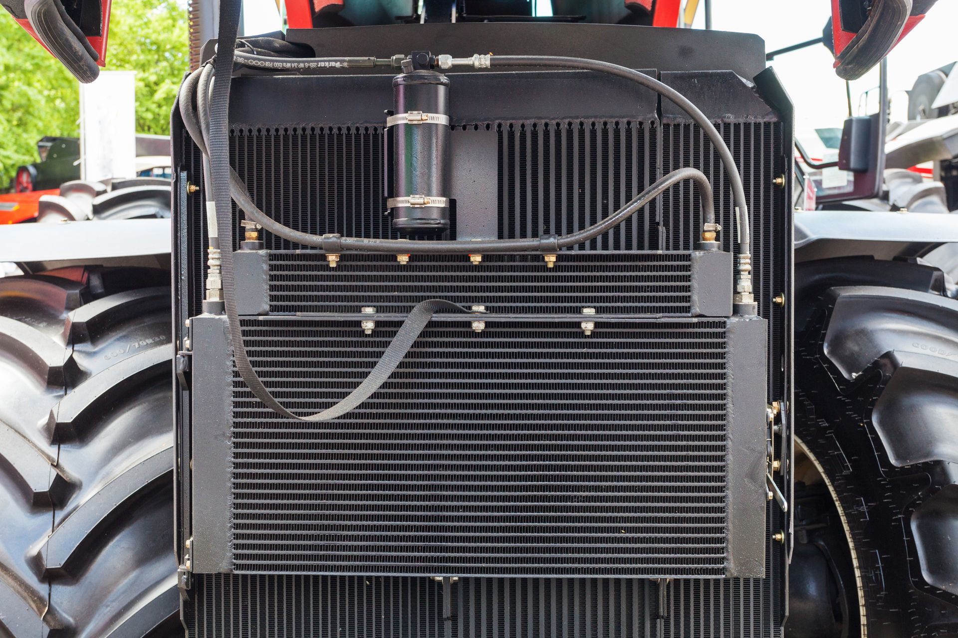 Front view of a tractor grille and engine compartment with large black tires on either side