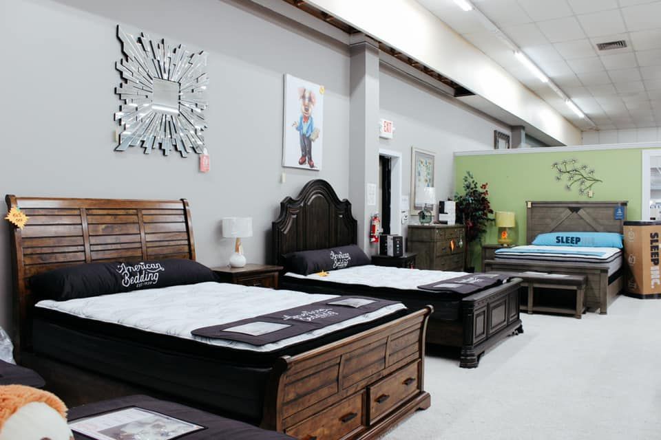 Mattress showroom with several beds on display in a bright, modern room