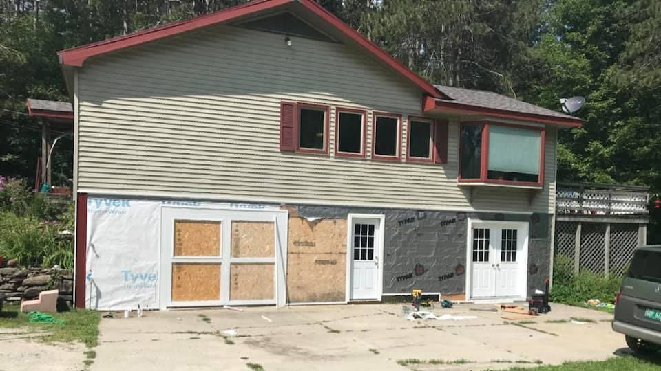 a house is being remodeled with a truck parked in front of it .