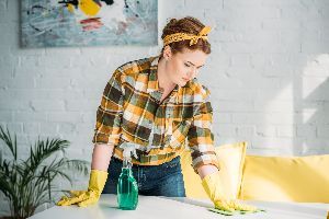 Beautiful Woman Dusting Table at Home — Nicholasville, KY — Stewart Air Conditioning & Heating