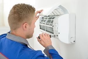 Male Technician Repairing Air Conditioner — Nicholasville, KY — Stewart Air Conditioning & Heating