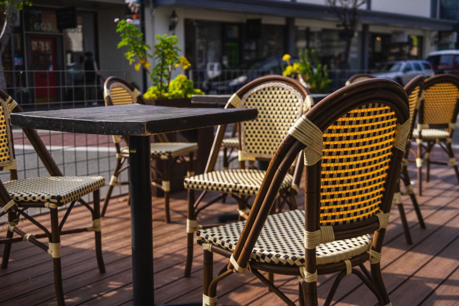 Outdoor café patio with wicker chairs and tables in warm sunlight