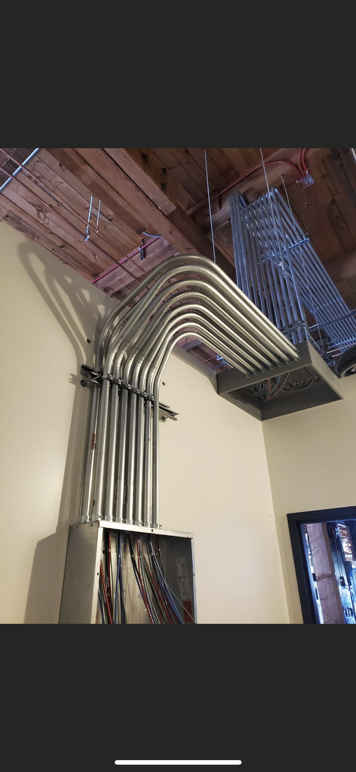 A bunch of metal pipes are hanging from the ceiling of a room.