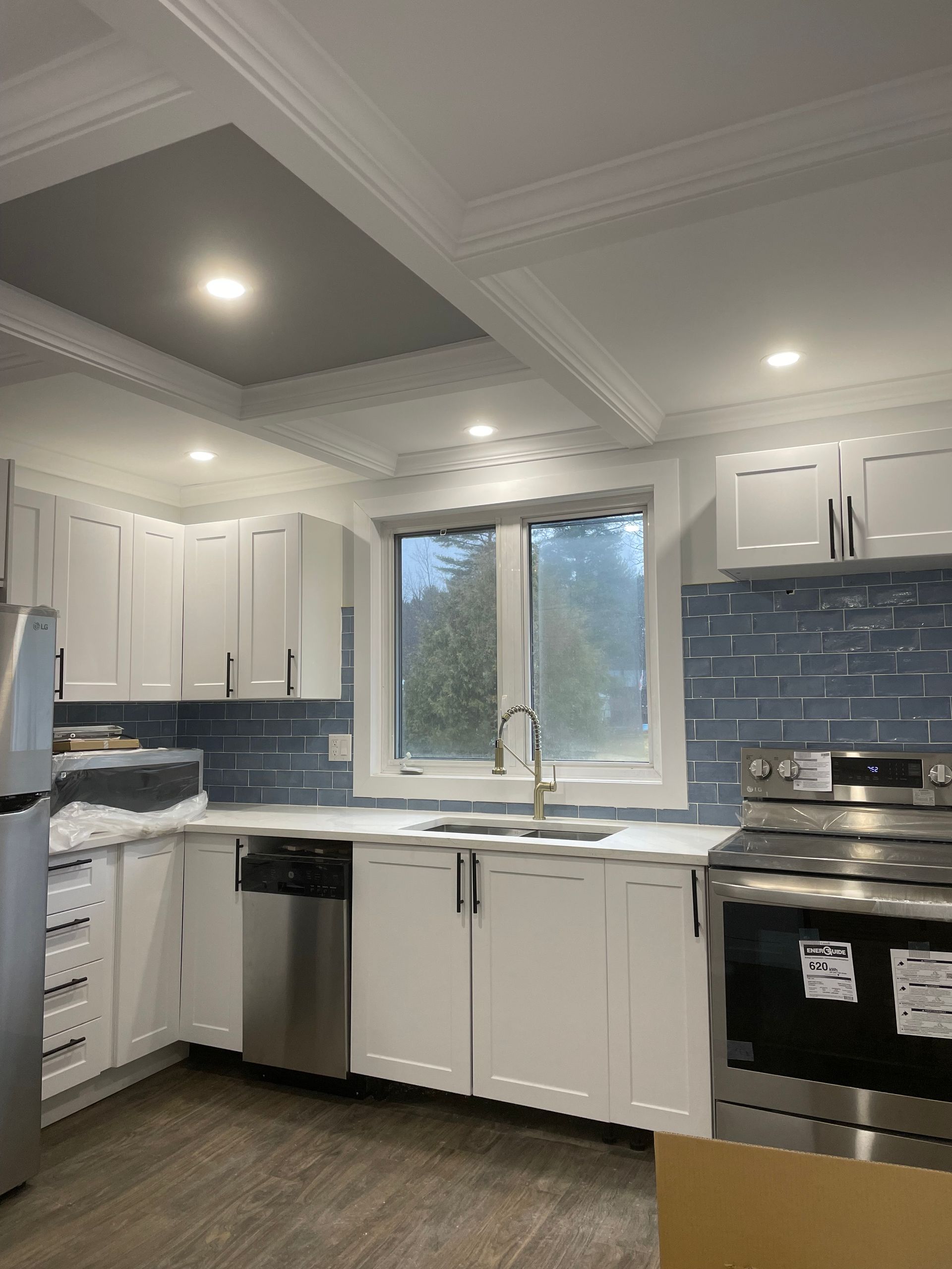 A kitchen with white cabinets and stainless steel appliances