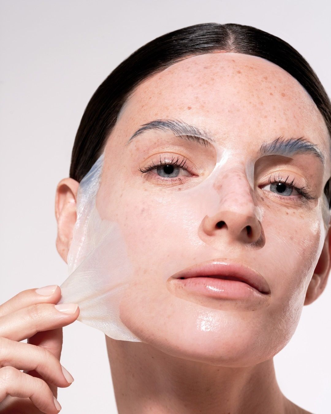 Une femme enlève un masque de son visage.