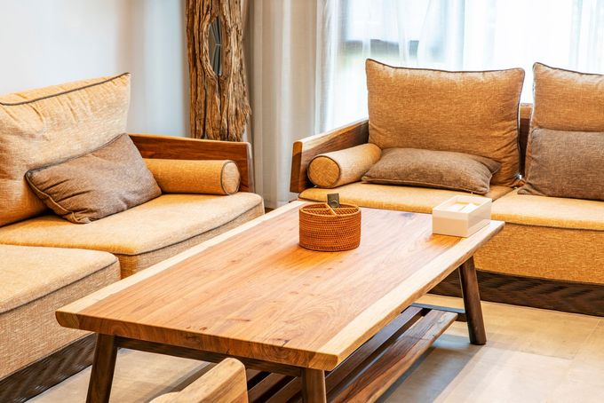 Accogliente soggiorno con divani beige, un tavolino da caffè in legno e una calda luce naturale.