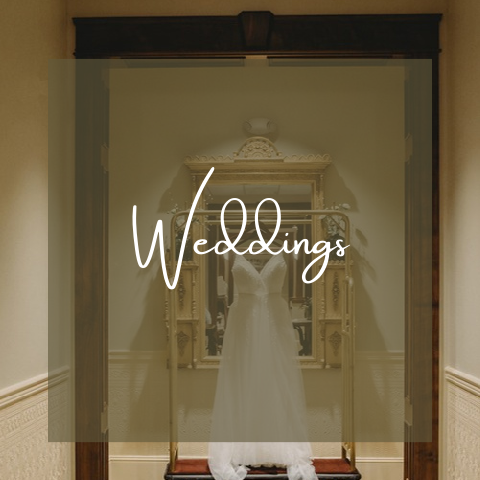 Wedding dress hanging on a rack in a hallway.