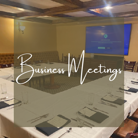 Meeting room set for business meetings with large screen and tables.